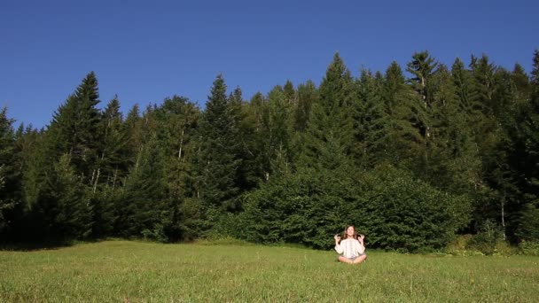 Niña meditando frente al bosque — Vídeos de Stock