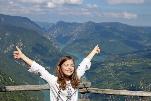 Menina feliz com polegares para cima na montanha — Fotografia de Stock