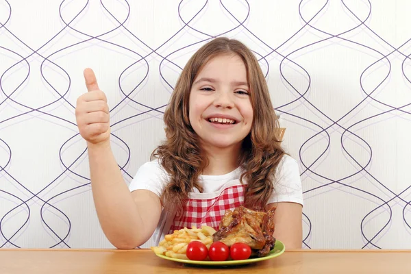 Happy little girl with roasted chicken wings and thumb up — Stock Photo, Image