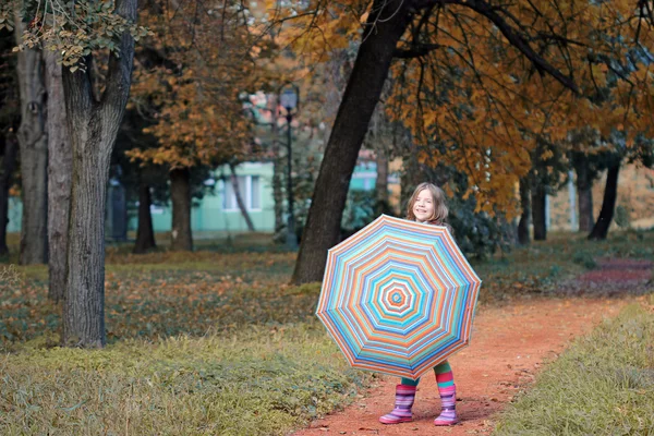 Beautiful little girl with umbrella in park autumn season — Stock Photo, Image