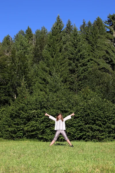 Lycklig Liten Flicka Med Tummen Upp Stående Framför Skogen — Stockfoto