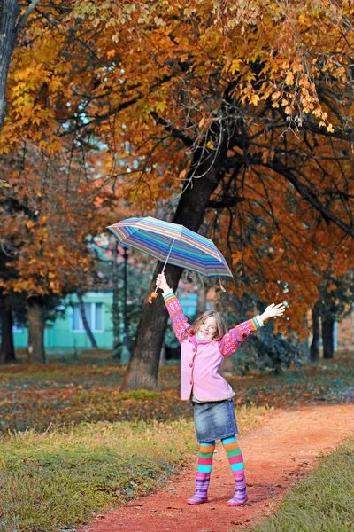 Happy little girl with hand up in park autumn season — Stock Photo, Image
