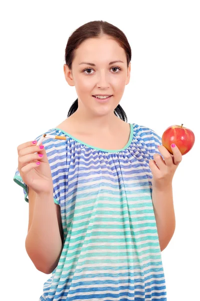 Девушка держит сломанную сигарету и яблоко — стоковое фото