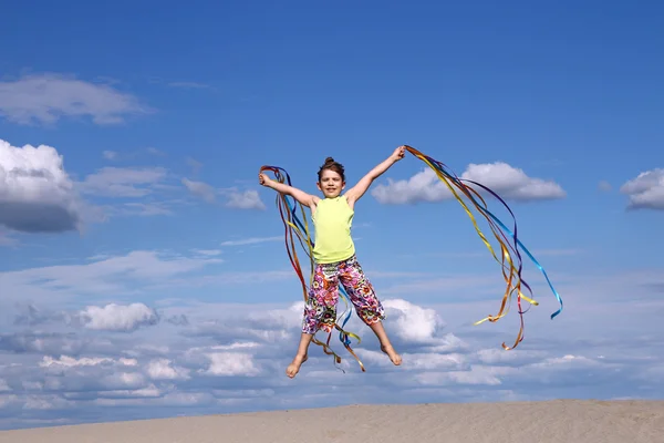 快乐的小女孩，在沙滩上跳跃 — 图库照片