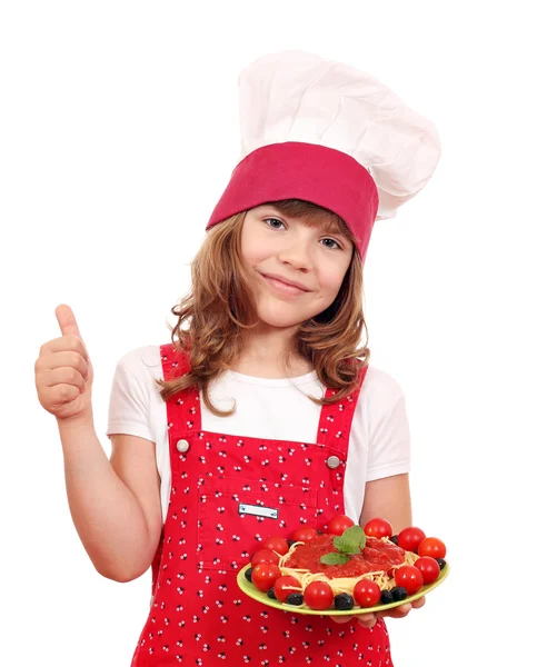 Счастливая маленькая девочка готовить со спагетти и большим пальцем вверх — стоковое фото
