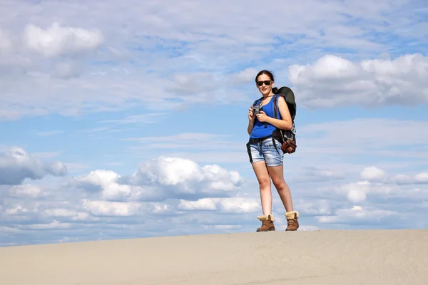 Girl with camera hiking in desert — Stock Photo, Image