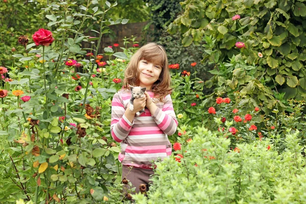 Kleines Mädchen mit Kätzchen im Garten — Stockfoto