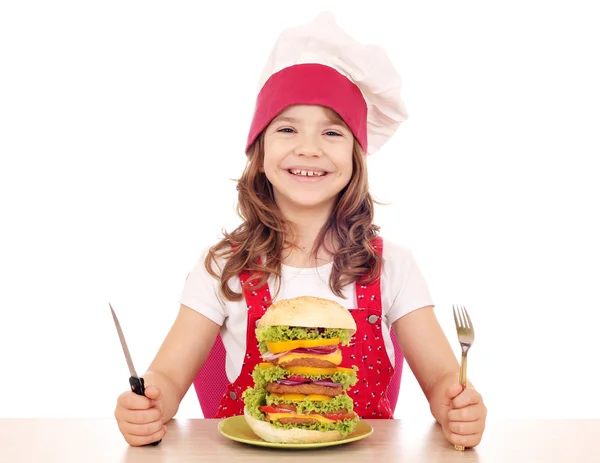Hungry little girl cook with big hamburger — Stock Photo, Image