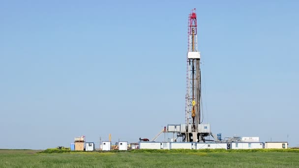 Oil drilling rig on green wheat field — Stock Video