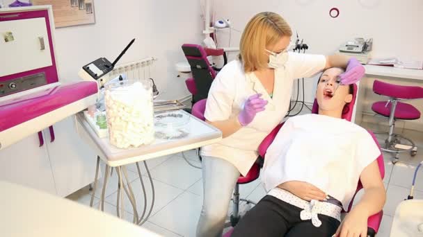 Dişçi ofisinde Bayan diş hekimi ve kız hasta — Stok video