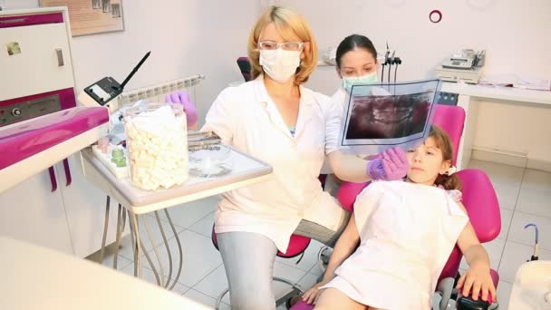 Жінка-стоматолог і медсестра оглядають рентгенівський знімок — стокове відео