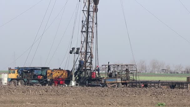 Campo petrolífero con trabajadores y plataforma de perforación de tierra — Vídeo de stock