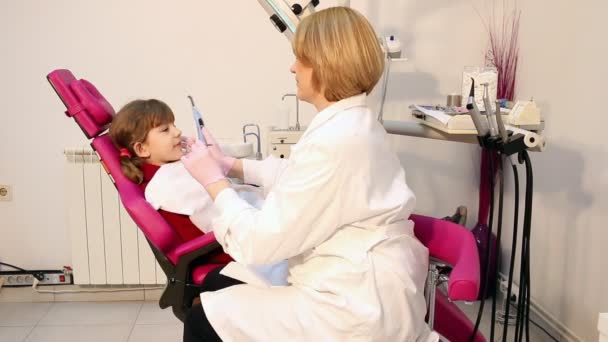 Niña pequeña paciente y dentista femenino — Vídeo de stock