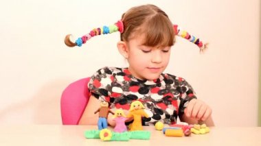 küçük kız hamuru ile aile figürü yapmak