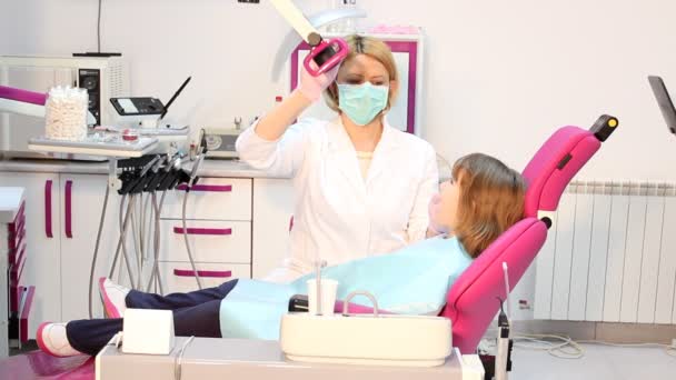 Zahnarzt untersucht Zähne eines kleinen Mädchens — Stockvideo