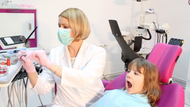 Mujer dentista y niña pequeña paciente — Vídeo de stock