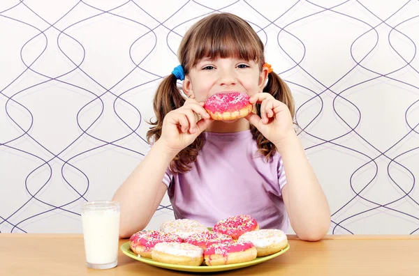 Menina comendo donuts doces — Fotografia de Stock