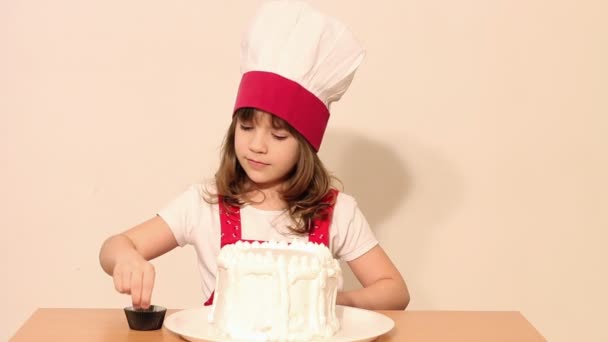 Petite fille cuisinier décore un gâteau — Video