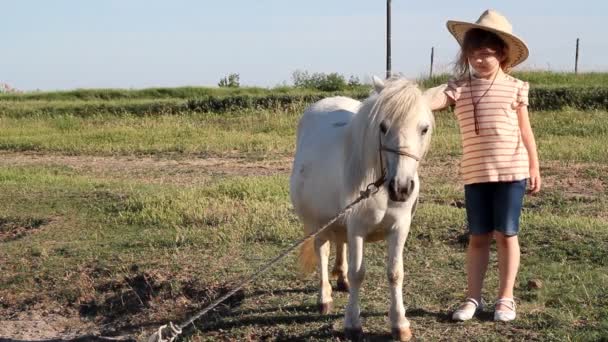 Menina com chapéu de cowboy e cavalo de pônei — Vídeo de Stock