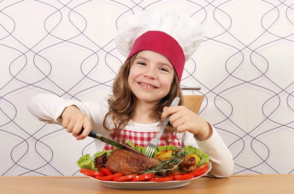 Happy little girl cook eating big turkey drumstick — Stock Photo, Image