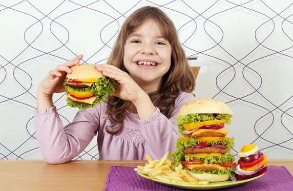 Hungrig liten flicka äter hamburgare — Stockfoto