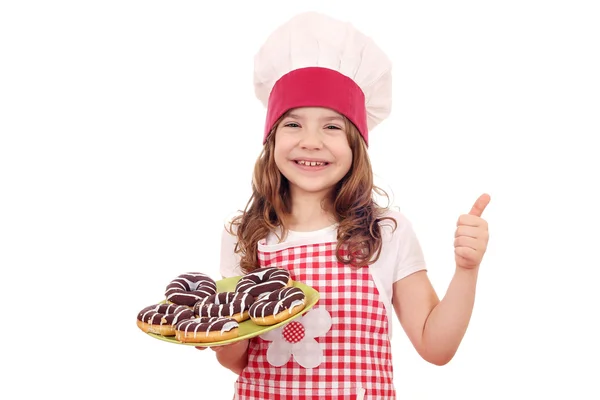 Niña feliz con donas de chocolate y el pulgar hacia arriba — Foto de Stock