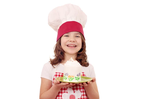 Heureuse petite fille cuisinier avec grand cupcake — Photo