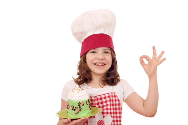 Felice bambina cuoco con cupcake e ok segno mano — Foto Stock