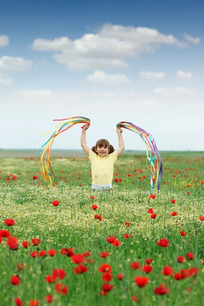 Heureuse petite fille jouer avec des rubans colorés sur prairie de printemps — Photo