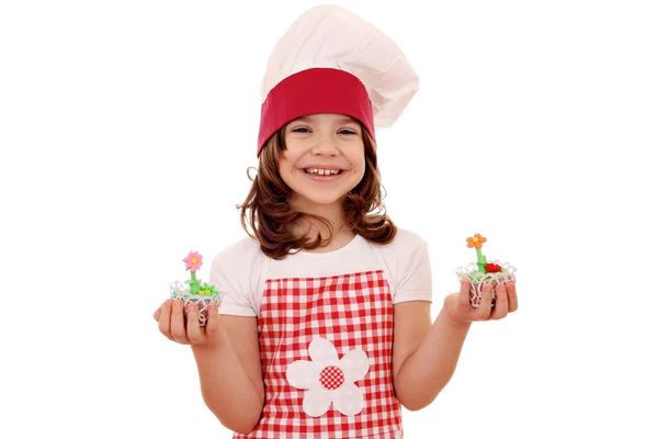 Menina feliz cozinhar segurando muffin doce — Fotografia de Stock