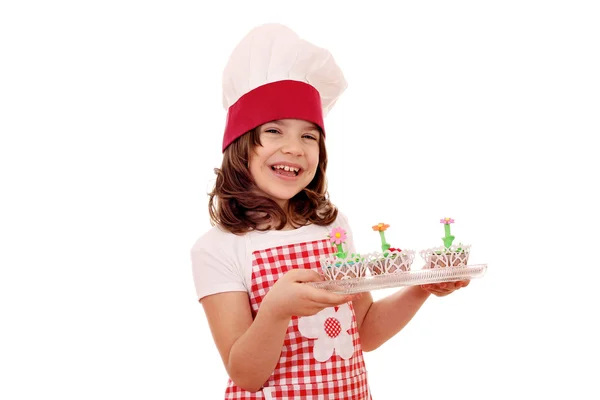 Menina feliz cozinheiro com saborosas flores de primavera muffins — Fotografia de Stock