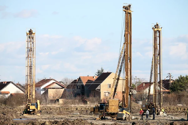 Sitio de construcción con trabajadores y tres mach de perforación hidráulica — Foto de Stock