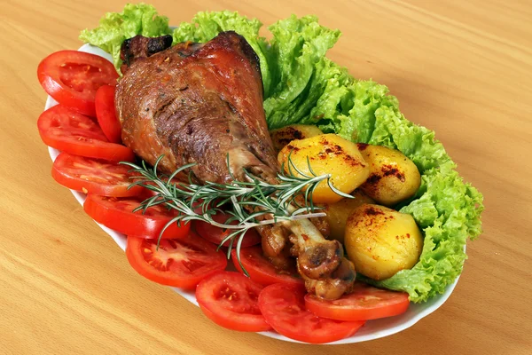 Turkey drumstick with vegetables on plate — Stock Photo, Image