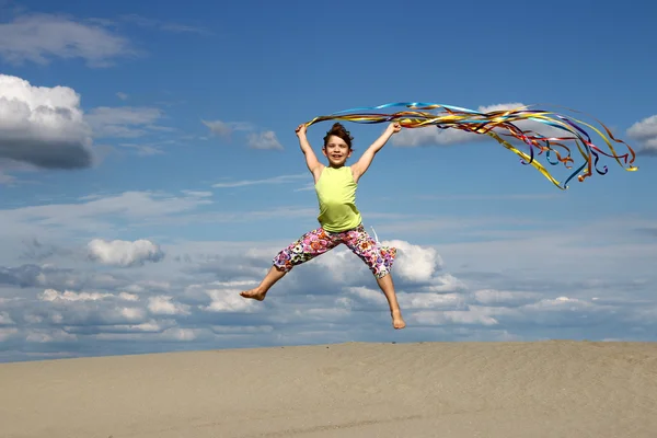 Happy little girl jumping on the beach — Stock Photo, Image