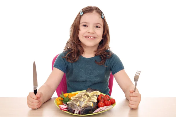 Menina com fome com peixes para o almoço — Fotografia de Stock