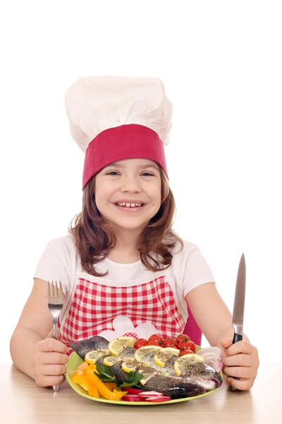 Menina feliz cozinhar com peixe preparado pronto para o almoço — Fotografia de Stock