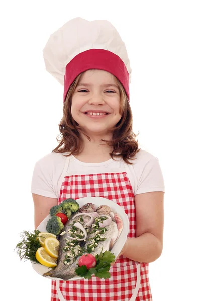 Mutlu küçük kız pişirmek plaka üzerinde hazır alabalık ile — Stok fotoğraf