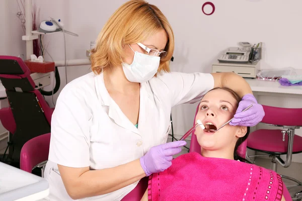 Dentista y paciente niña en el consultorio del dentista — Foto de Stock