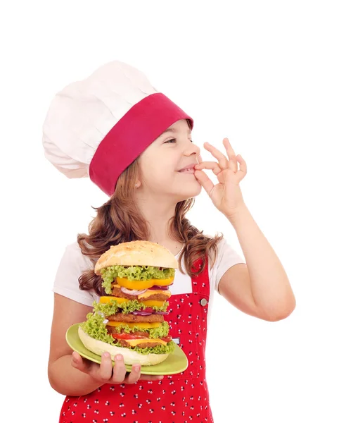 Niña cocinera con hamburguesa grande y señal de mano ok — Foto de Stock