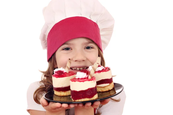 Menina feliz cozinhar com bolo de framboesa doce — Fotografia de Stock