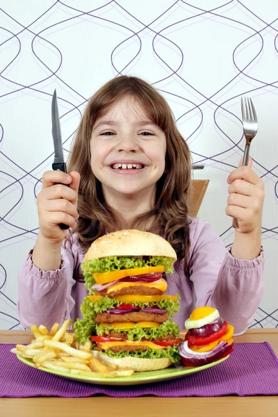 Niña feliz con hamburguesa grande listo para el almuerzo — Foto de Stock