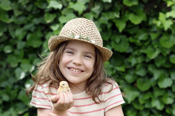 Glad liten tjej anläggning kyckling — Stockfoto