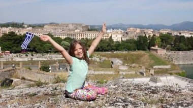 Corfu town Yunanistan ile Yunan bayrağı sallayarak mutlu küçük kız