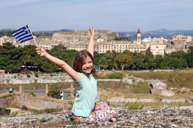 Corfu town Yunanistan ile Yunan bayrağı sallayarak mutlu küçük kız