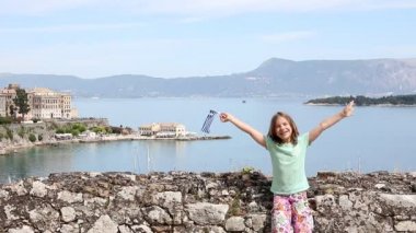 Corfu town Yunanistan Yunan bayrağı sallayarak mutlu küçük kız