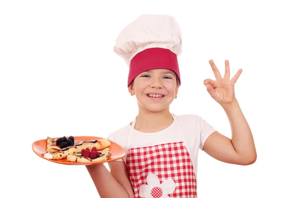 Gelukkig meisje koken met pannenkoeken en ok hand teken — Stockfoto