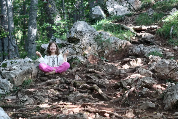 Malá holčička meditoval v lese — Stock fotografie