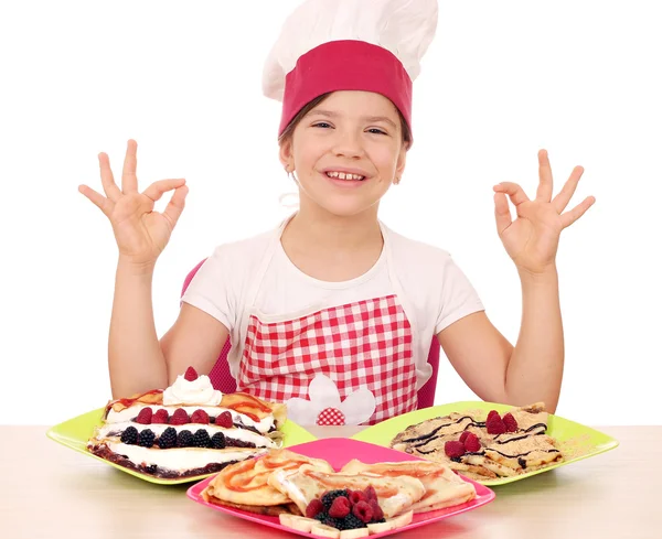 Menina feliz cozinhar com crepes deliciosos na mesa e ok han — Fotografia de Stock