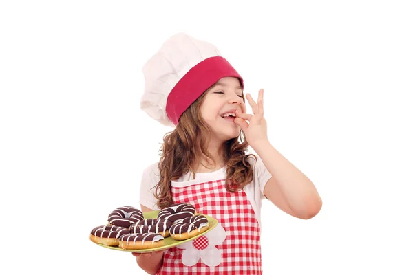 Menina feliz cozinhar com donuts de chocolate e sinal de mão ok — Fotografia de Stock