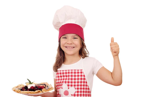 Menina feliz cozinhar com crepes e polegar para cima — Fotografia de Stock